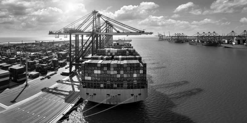 Aerial view of cargo ship and cargo container in harbor.